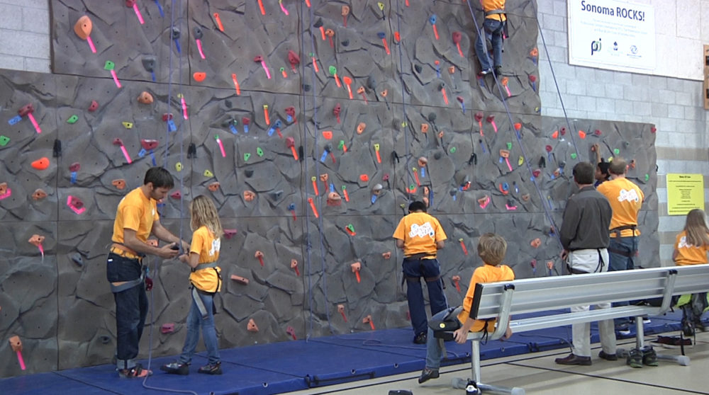 Kevin Jorgeson helps a Boys and Girls Club member with her harness.