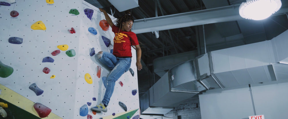 A Chicago Boys and Girls Club member gets to the top off the wall at First Ascent in Chicago.