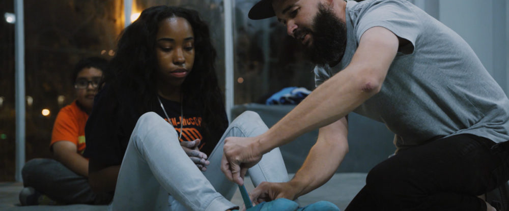 A Chicago Boys and Girls Club member tries on climbing shoes for the first time.