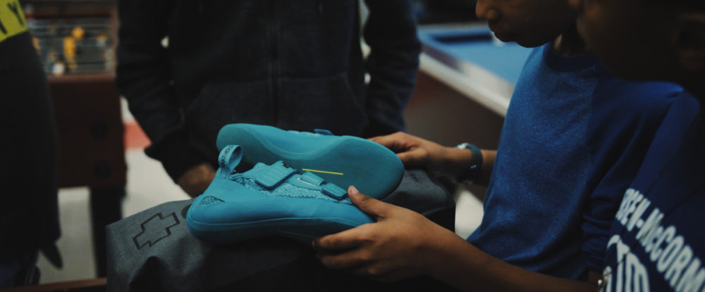 A Boys and Girls club member checks out So iLL climbing shoes for the first time.