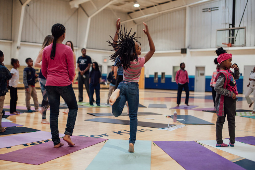 Saint Louis Boys and Girls club members try yoga before the opening of the wall.