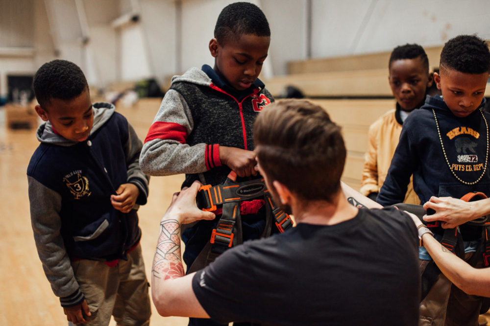 Climb So iLL staff helps fit harnesses to Boys and Girls Club of Saint Louis members.