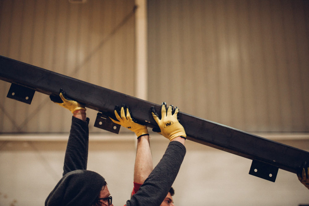 An ElDorado team member helps lift an iron beam.