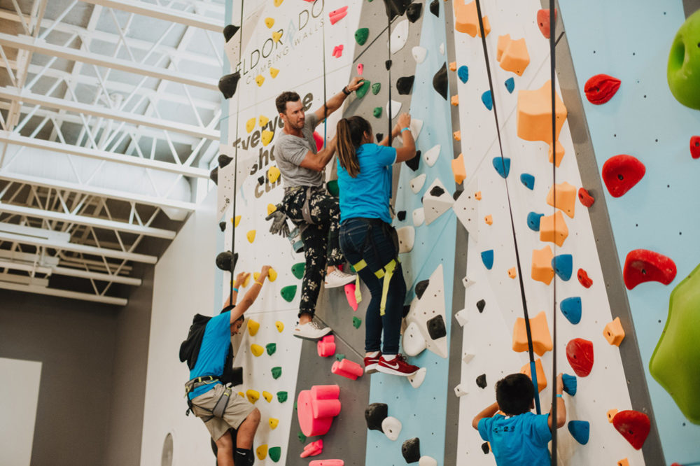 TOMS founder Blake Mycoskie encourages a LA Variety Boys and Girls Club member up the wall.