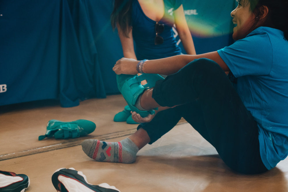 An LA Variety Boys and Girls Club member tries on So iLL climbing shoes for the first time.