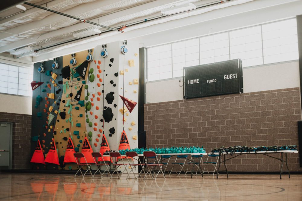 Harnesses and climbing shoes are laid out on a table prior to launching the new 1Climb wall